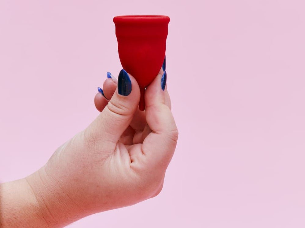 Eine Hand hält eine Menstruationstasse